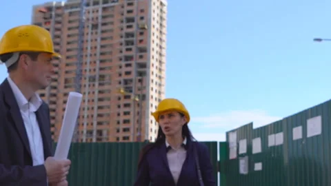 Three businessmen an architect and an engineer are standing at a construction Stock Footage 89432517