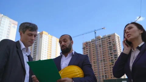 Three businessmen an architect and an engineer stand on the construction site Stock Footage 89433835