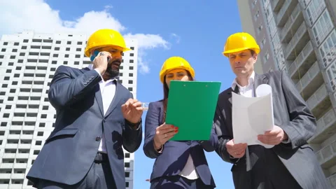 Three businessmen an architect and an engineer stand on the construction site Stock Footage 89434708