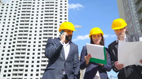 Three businessmen an architect and an engineer stand on the construction site Stock Footage 89435260