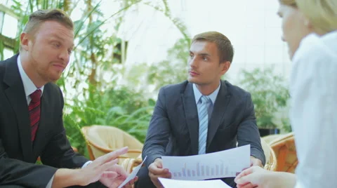 Three businessmen discuss charts in documents Video stock 57457517