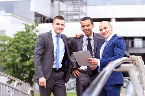 Three Businessmen Discussing Document Outside Office Foto stock