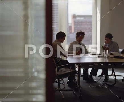 Three businessmen meeting in conference room Stock Photos