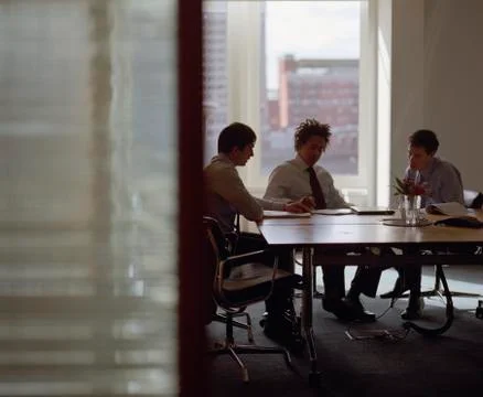 Three businessmen meeting in conference room Stock Photos