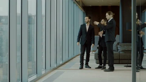 Three businessmen talking, beginning to dance, stopping and talking again. 4K Stock Footage 89824135