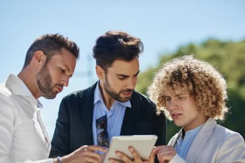 Three businessmen using tablet outside Stock Photos