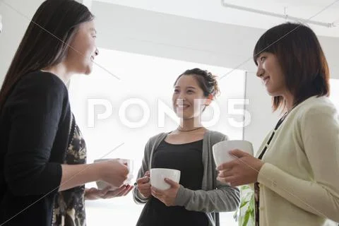 Three businesswomen on the coffee break in the office Stock Photos