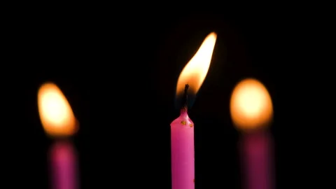 Three cake candles burning on a black background. Stock Footage 303434349