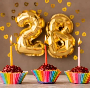 Three cakes-baskets with candles on the 28th birthday Stock Photos