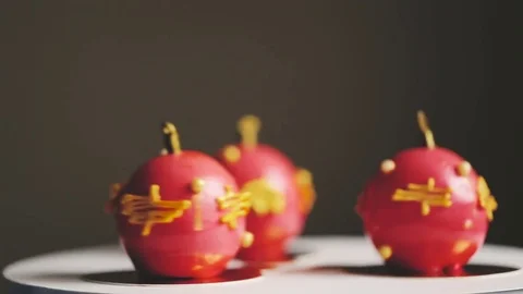 Three cakes in red glaze in the form of a Christmas tree toy are spinning on a 库存影片 83541643