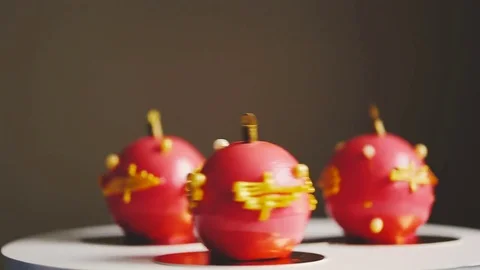 Three cakes with red mirror glaze and chocolate Christmas ornament are spinning Vidéo 83541584