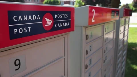 Three canada post community mailboxes with logo top frame left and pedestrian Stock Footage 246133183