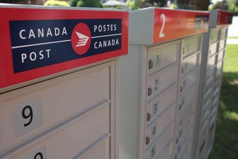 Three canada post community mailboxes with logo top frame left Stock Photos