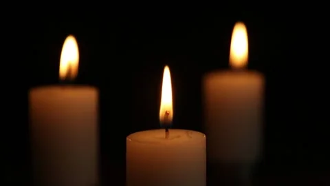 Three candle flames flickering in dark close-up scene Stock Footage 323180901