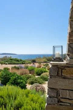 Three candle lantern on an authentic stone wall under a pergola. Stock Photos