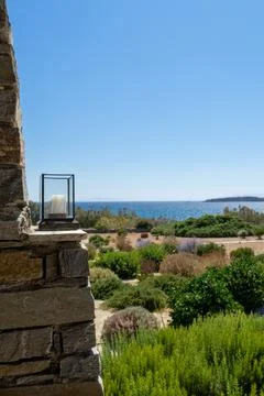 Three candle lantern on an authentic stone wall under a pergola. Stock Photos
