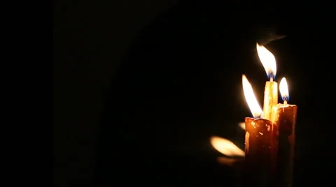 Three candles are burning on the background black. Video stock 60218191