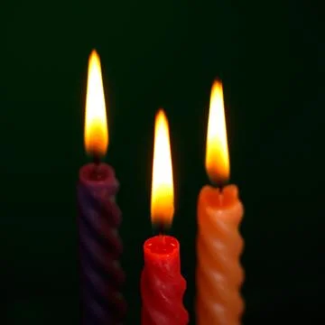 Three candles on black Stock Photos