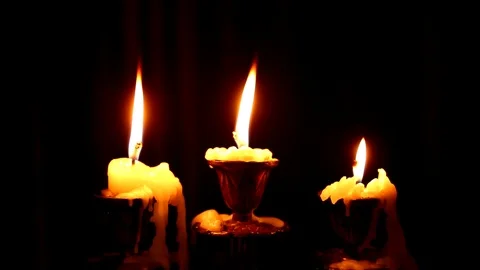 Three candles burn in a candlestick on black background. Stock Footage 123505849