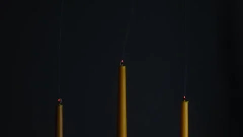 Three candles burning and gradually decreasing in height on black background 库存影片 312984296