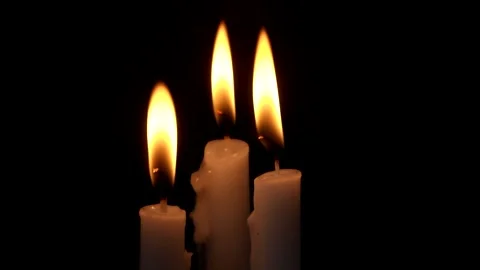 Three candles burning on black backgroun... | Stock Video | Pond5