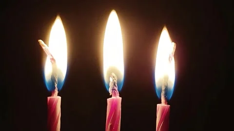 Three Candles Burning on a Black Background Stock Footage 317900938