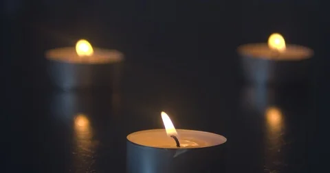 Three Candles Burning on a Black Table Stock Footage 101373633