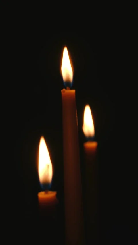 Three candles burning in the dark creating a warm glow Stock Footage 312982315