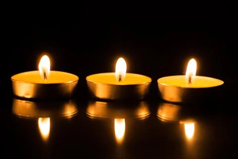 Three candles in the dark with reflection Stock Photos