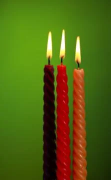 Three candles on green Stock Photos