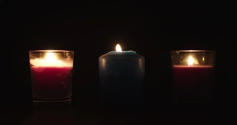 Three candles lit in the dark. Concept: spirituality Stock Footage 127754606