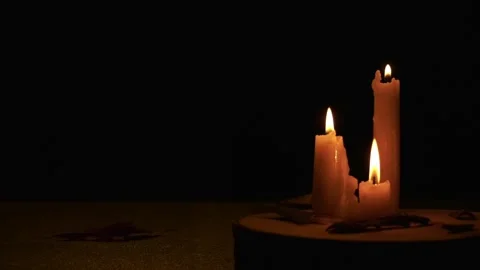 Three candles lit as leaves fall in autumn Stock Footage 294815606
