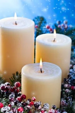 Three candles with snowfall Stock Photos