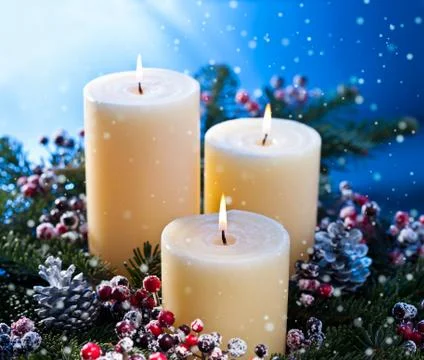Three candles with snowfall Stock Photos