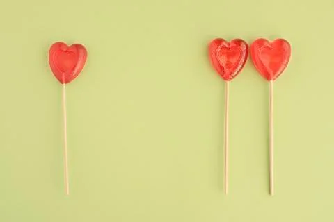 Three candy in heart shape on green background Stock Photos