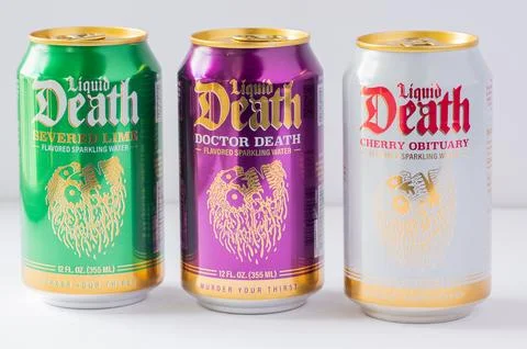 Three cans of Liquid Death flavored sparkling water lined up on a white bac.. Stock Photos
