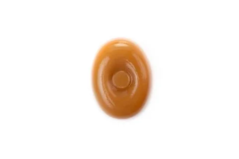Three caramel candies on a white background close-up. Stock Photos