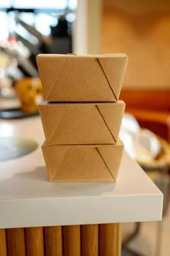 Three cardboard boxes stacked on a counter indoors. Stock Photos