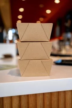 Three cardboard boxes stacked on a counter indoors. Stock Photos