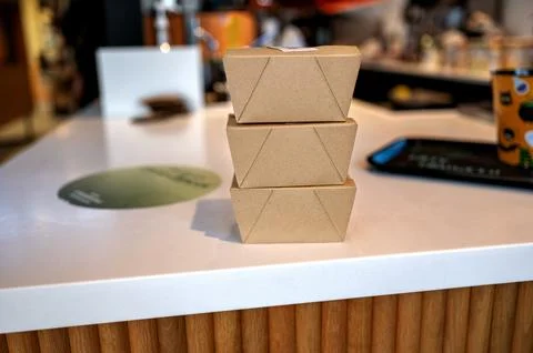 Three cardboard boxes stacked on a counter indoors. Stock Photos