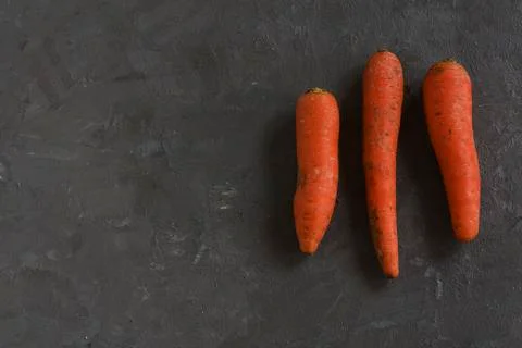 Three carrots on a grey table Stock Photos