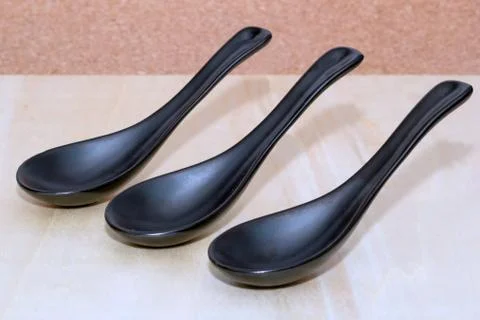 Three ceramic black spoons Stock Photos