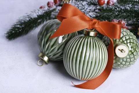 Three Ceramic Christmas baubles with red bow on a light background. Stockfoto's