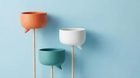 Three ceramic planters shaped like speech bubbles on sticks against light b.. Illustrazione stock