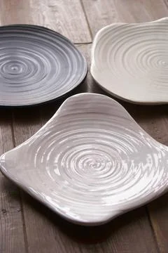 Three ceramic plates with spiral texture on wooden table rustic Stock Photos