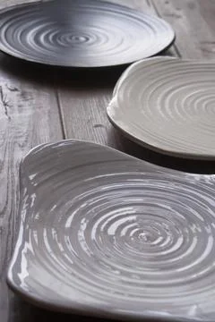 Three ceramic plates with spiral texture on rustic wooden Stock Photos