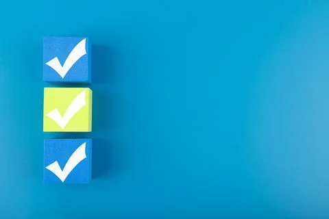 Three checkmarks on blue and yellow cubes against blue background with copy Stock Photos