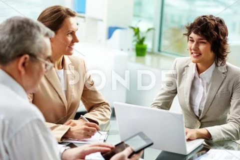Three cheerful business people holding a meeting to exchange new information Stock-Fotos