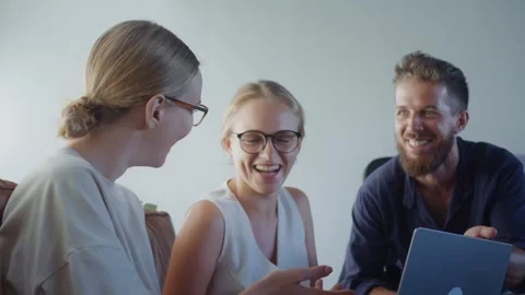 Three cheerful colleagues are collaborating on project, sharing ideas and Stock Footage 312114570