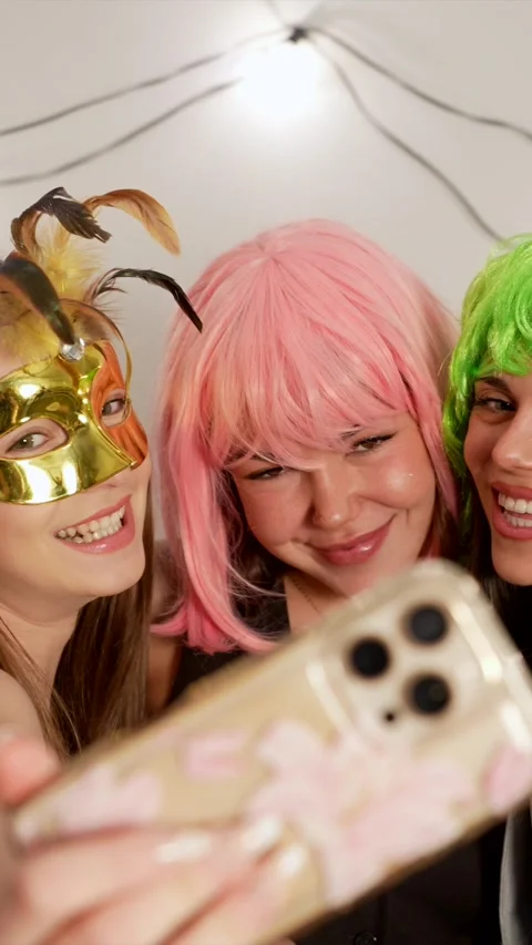 Three cheerful female friends taking selfie at costume party Stock Footage 324465935